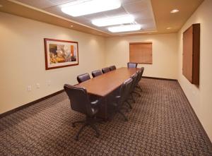 a conference room with a wooden table and chairs at Candlewood Suites Bellevue by IHG in Bellevue
