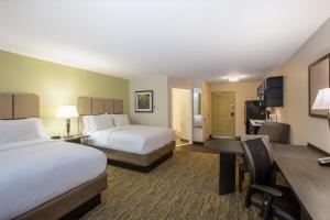 a hotel room with two beds and a desk at Candlewood Suites Bellevue by IHG in Bellevue +33 photos