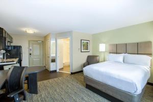 a hotel room with a bed and a kitchen at Candlewood Suites Bellevue by IHG in Bellevue