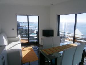 a dining room with a table and chairs and the ocean at Casa Das Dias in Vila Franca do Campo