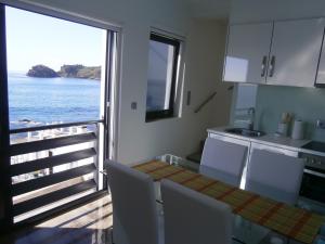 a kitchen with a table and a view of the ocean at Casa Das Dias in Vila Franca do Campo