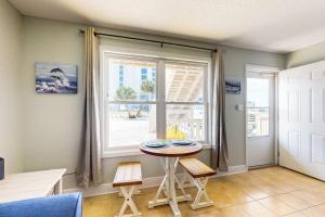 a table and chairs in a room with a window at Spacious Condo with full kitchen shared pool and beach access in Perdido Key