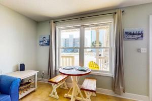 a living room with a table and a window at Spacious Condo with full kitchen shared pool and beach access in Perdido Key