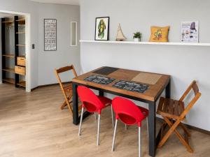 a dining room table with four red chairs at Apê completo bem no centro in Joinville
