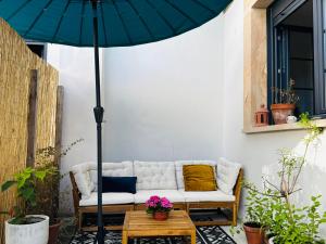 a couch sitting on a patio under an umbrella at El cuarto AZUL in Urrugne