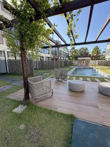 a patio with chairs and a tree in a building at Villa 18 Atins Rooftop com piscina in Barreirinhas