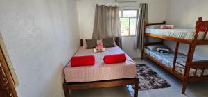 a bedroom with two bunk beds with red pillows at recanto provetá ILHA GRANDE in Praia de Provetá 