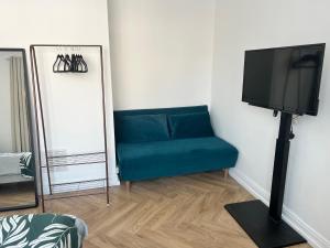 a living room with a blue couch and a flat screen tv at At Number 36 in London