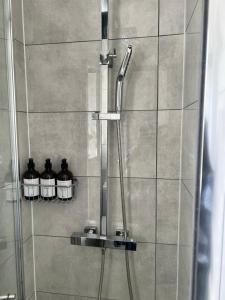 a shower with three bottles in a shower stall at At Number 36 in London