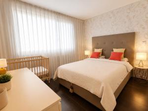 a bedroom with a large bed with red pillows at Bom dia Parque Nações LisboaX in Lisbon