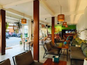 a restaurant with couches and tables and chairs at Ashana Hotel in Uluwatu