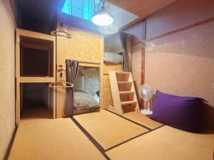 a small room with a bunk bed and a ladder at Hakuba Hospitality Inn YUKINOSO in Hakuba