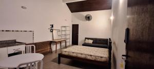 a small room with a bed and a table and chairs at Apartamento Beira do Valo in Iguape