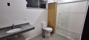 a bathroom with a toilet and a sink and a shower at Apartamento Beira do Valo in Iguape