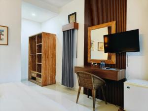 a room with a desk with a mirror and a mirror at Ashana Hotel in Uluwatu