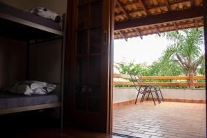 a bedroom with a balcony with a bed and a chair at Hostel Terraço Urbano in Sao Jose do Rio Preto