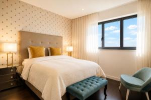 a bedroom with a bed and a blue chair at Bom dia Parque Nações LisboaX in Lisbon