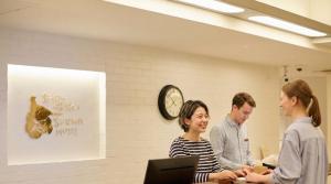a group of people standing around a table with a laptop at Shin-Osaka Station Hotel in Osaka