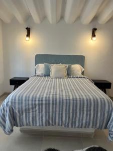 a bed with a blue and white striped comforter in a bedroom at Departamento in Lo de Marcos
