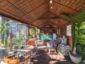 a screened in porch of a house with a table and chairs at The Bali Room in Coromandel Town +36 photos