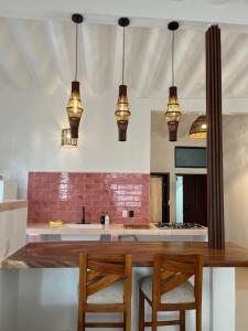 a kitchen with pendant lights and a table with chairs at Departamento in Lo de Marcos +9 photos