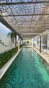 a swimming pool under a canopy with green water at Aroha Villa in Banjar