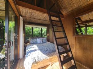 a bedroom with a bunk bed and a ladder at The Bali Room in Coromandel Town