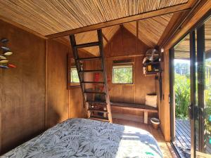 a bedroom with a bunk bed and a ladder at The Bali Room in Coromandel Town