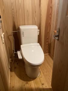 a bathroom with a white toilet in a wooden room at 心のふれあい民泊 in Shimanto