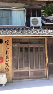 a building with a door with a chair on top at 心のふれあい民泊 in Shimanto