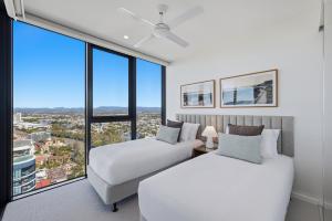 two beds in a room with a large window at Amaya in Gold Coast +19 photos
