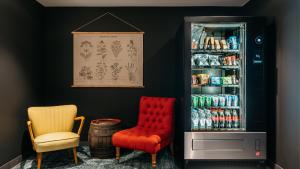 a room with two chairs and a drink cooler at Ruby Hanna Hotel Stuttgart by IHG in Stuttgart