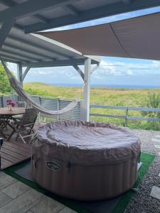 a large round bed on a deck with a hammock at Ti kaz belair in Le Diamant