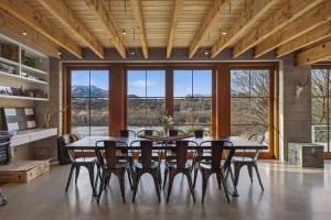 a dining room with a table and chairs and windows at Toi Point Lodge in Queenstown