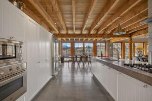 a large kitchen with white cabinets and a counter top at Toi Point Lodge in Queenstown +19 photos