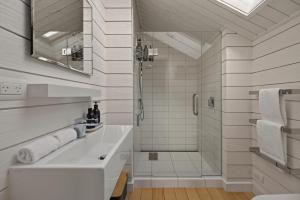 a white bathroom with a sink and a shower at Toi Point Lodge in Queenstown