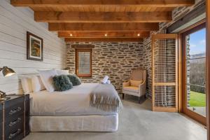 a bedroom with a bed and a stone wall at Toi Point Lodge in Queenstown