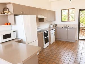 a kitchen with white appliances and a tile floor at Ocean Front on Malibu in Bawley Point +7 photos