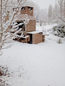 a brick fireplace covered in snow in a yard at "Alojamiento en Uspallata" para hasta 6 personas in Uspallata