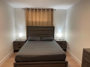a bedroom with a bed with two nightstands and two lamps at Orgive Suite - Private 1 Bedroom Apartment in Riverview