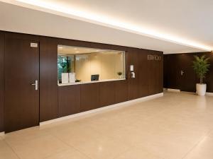 an empty lobby with wooden walls and a mirror at Bom dia Parque Nações Lisboa W in Lisbon