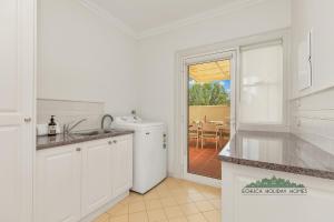 a white kitchen with a sink and a dishwasher at Llewoh on Crofton in Echuca