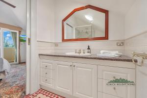 a white bathroom with a sink and a mirror at Llewoh on Crofton in Echuca +18 photos