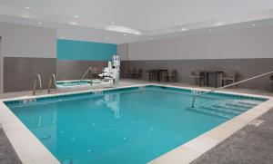 a large swimming pool with blue water in a building at avid hotel Wenatchee by IHG in Wenatchee