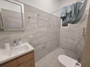 a bathroom with a sink and a shower and a toilet at Himara City 10 - Central, Beach Access in Himare