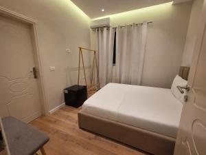 a bedroom with a white bed and a window at Himara City 10 - Central, Beach Access in Himare