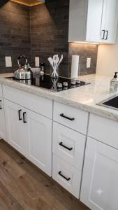 a kitchen with white cabinets and a counter top at Stylish Studio in Oleander Close to Downtown in Bakersfield