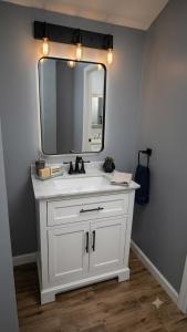 a bathroom with a white sink and a mirror at Stylish Studio in Oleander Close to Downtown in Bakersfield