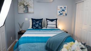 a bedroom with a bed with blue and white pillows at Stylish Studio in Oleander Close to Downtown in Bakersfield