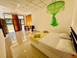a bedroom with a bed with a green item hanging from the ceiling at Traveller's Home Safari Resort in Udawalawe +53 photos